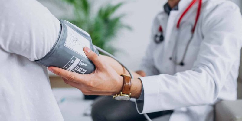 young-male-psysician-with-patient-measuring-blood-pressure-1-scaled